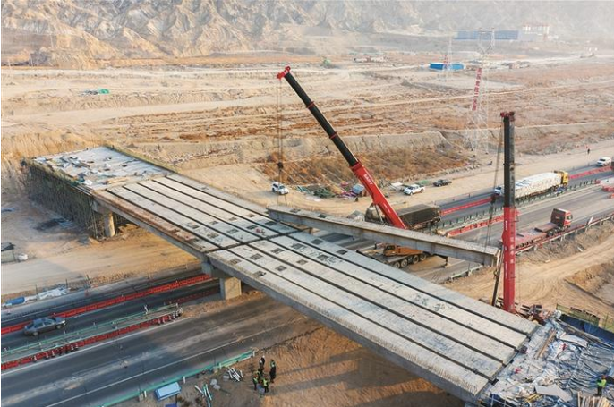 G3012吐和高速公路至铁门关市博古其镇高速出入口立交桥箱梁架设施工现场（资料图片）。该工程是G3012吐和高速与兵地融合项目G3012—博古其镇—库尔勒机场公路项目的起点和重要节点工程，由新疆北新路桥集团股份有限公司承建。苏江生 摄